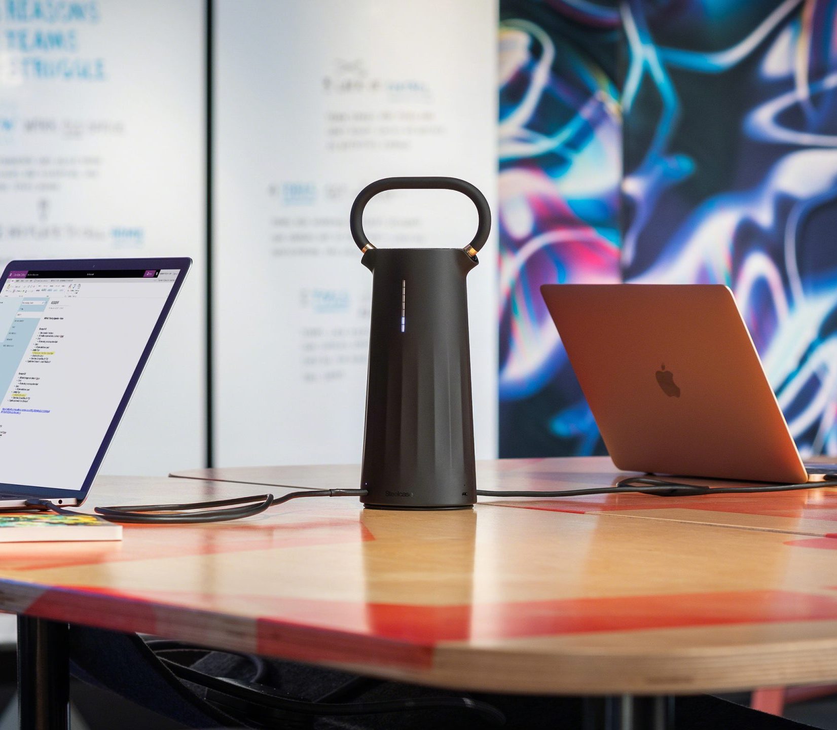 A Steelcase Flex mobile power unit sitting on a table in a nicely designed office space.