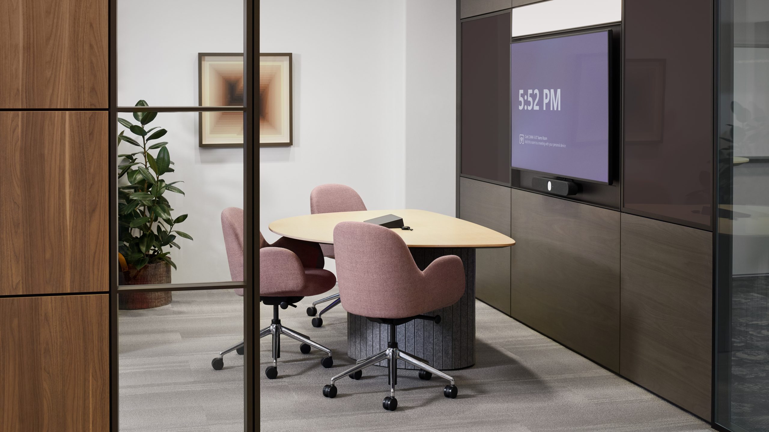 A Steelcase Ocular table is positioned facing a mounted television in an office setting.